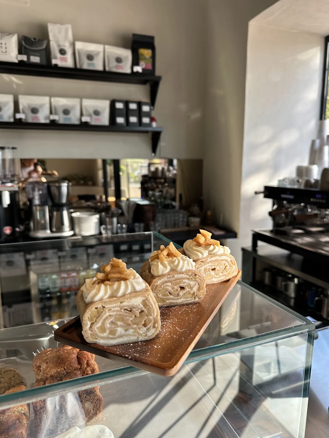 Pastries displayed on a wooden board in a bakery case