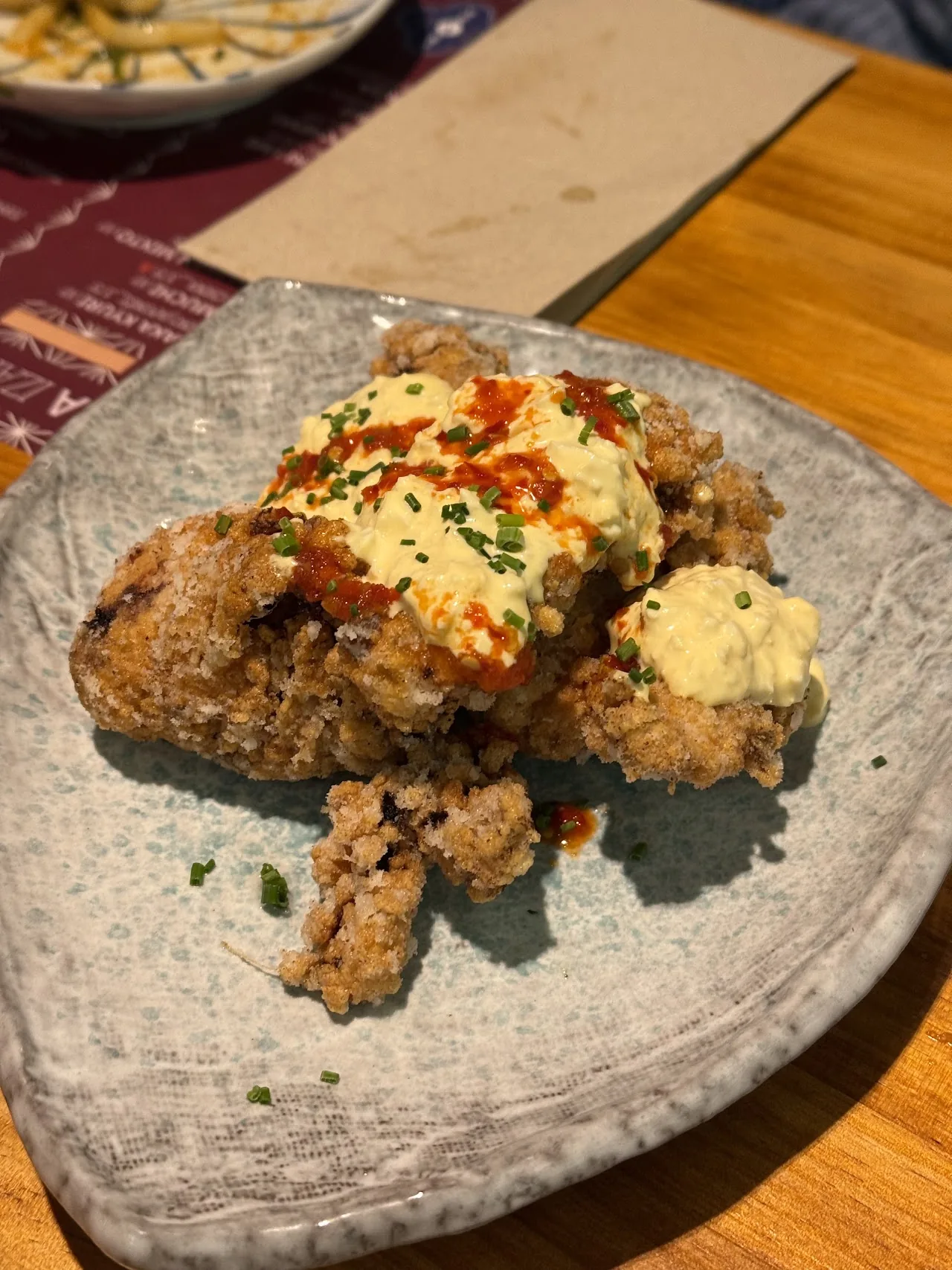 Plate of fried chicken karaage with a spicy sauce drizzle