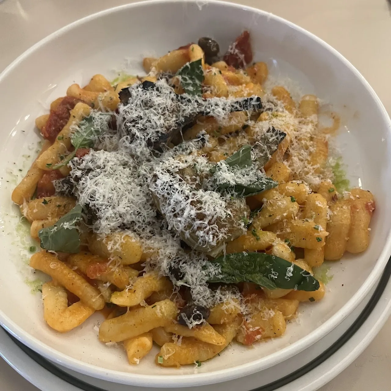Bowl of pasta with parmesan shavings and crispy sage