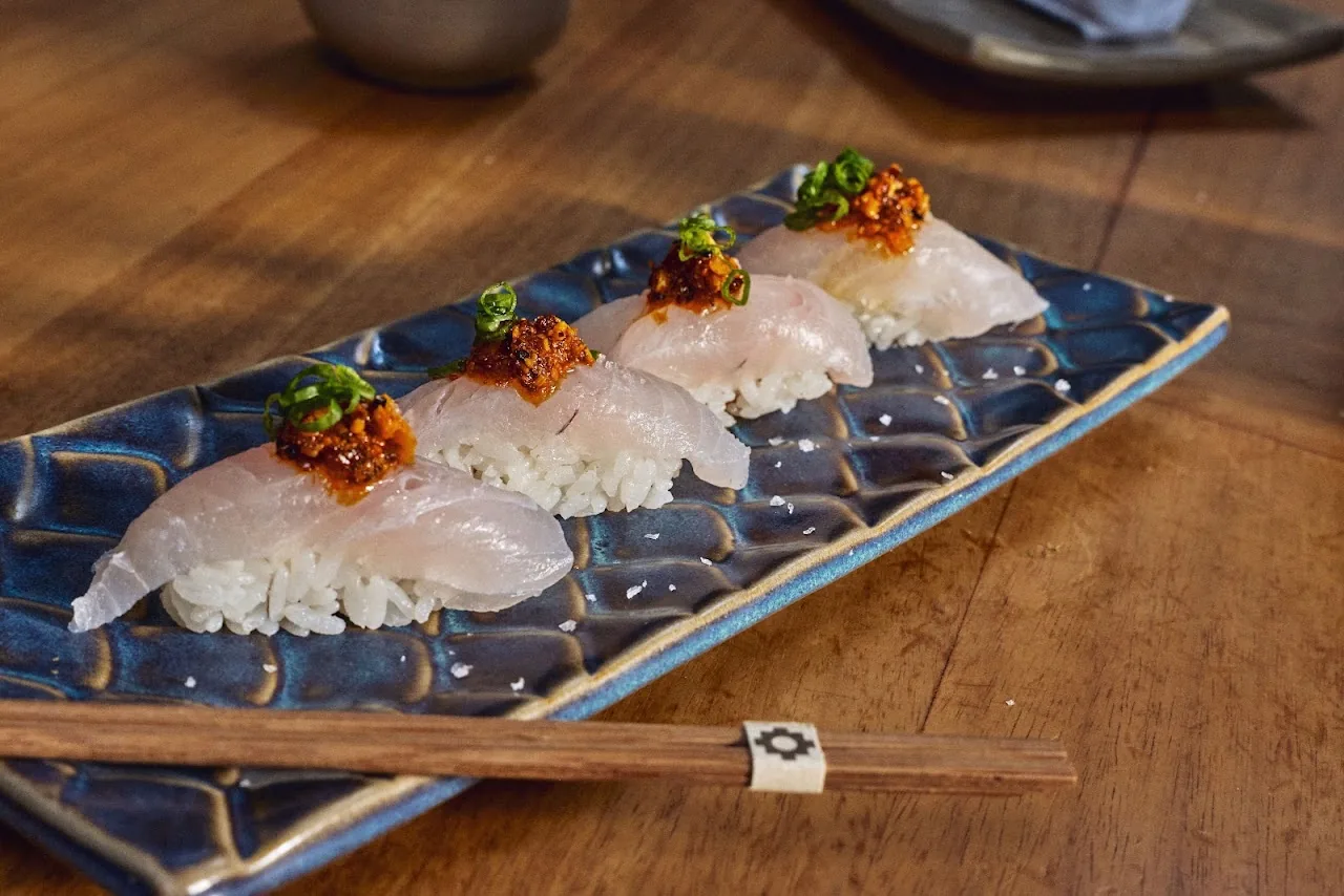 Nigiri sushi platter served on a dark patterned plate