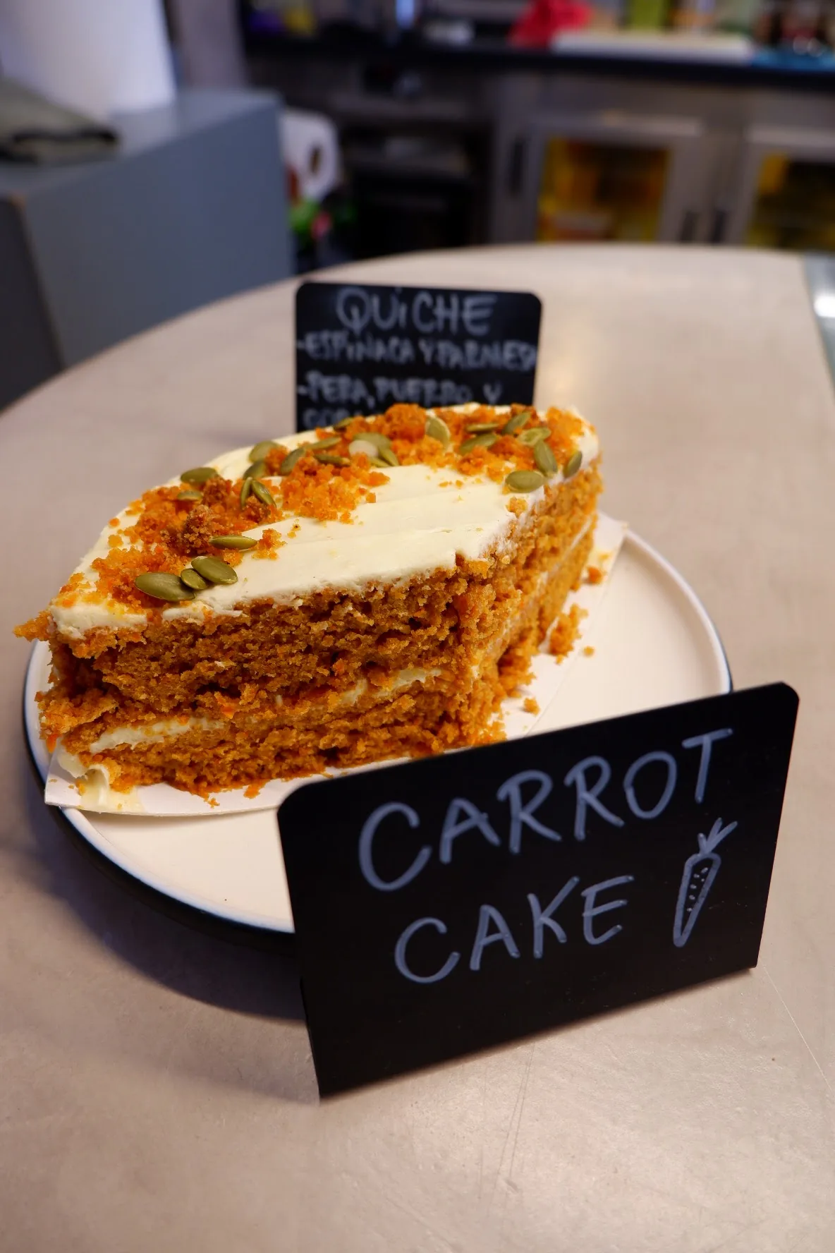 A slice of carrot cake with cream cheese frosting on a plate