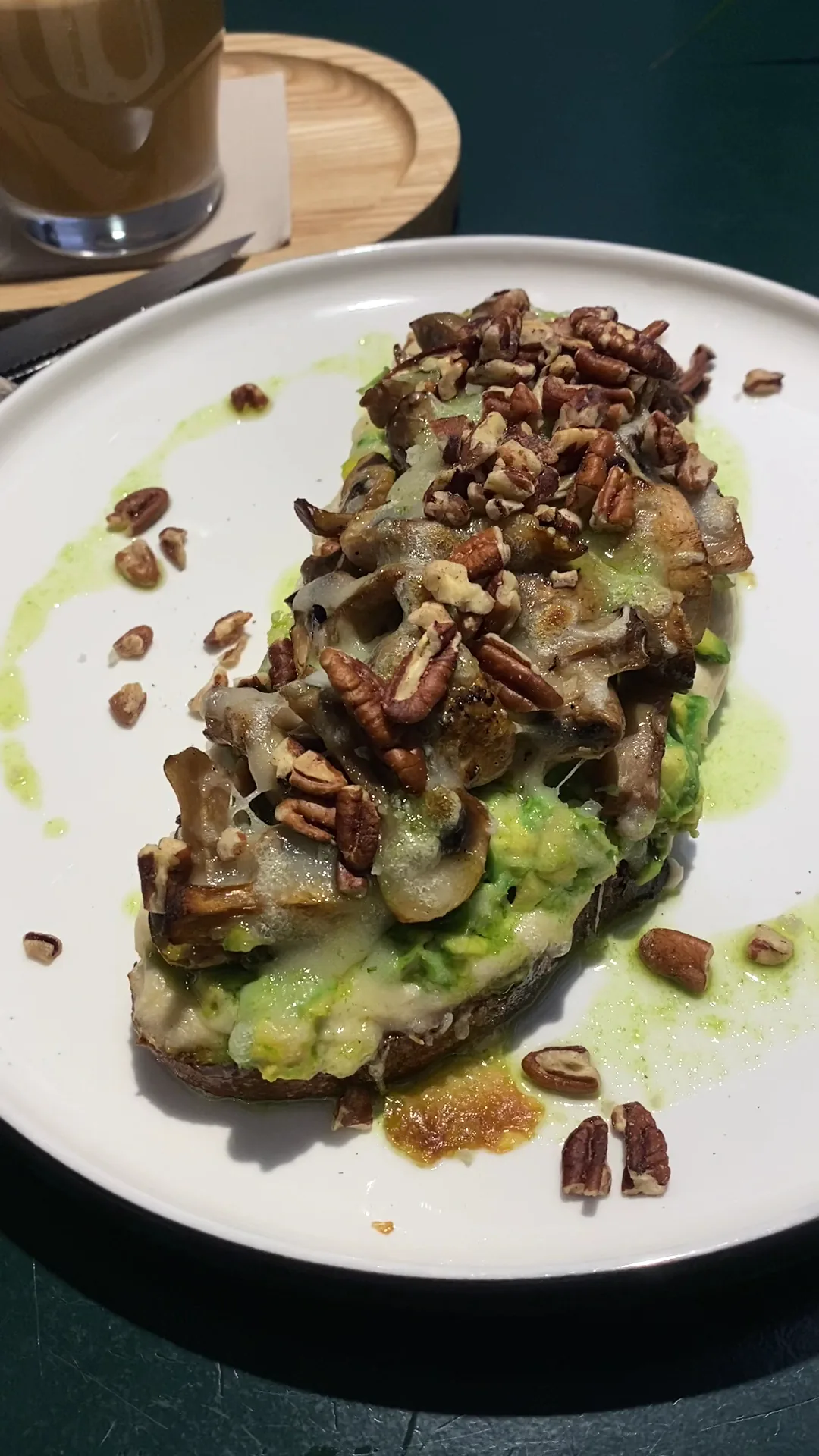 Avocado toast topped with pecans, drizzled with sauce