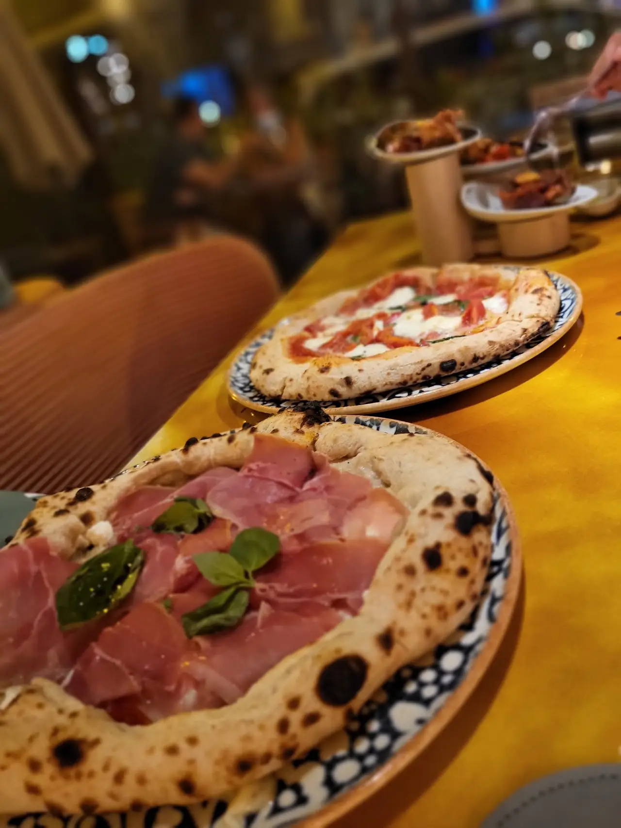 A pizza topped with sliced prosciutto and fresh basil