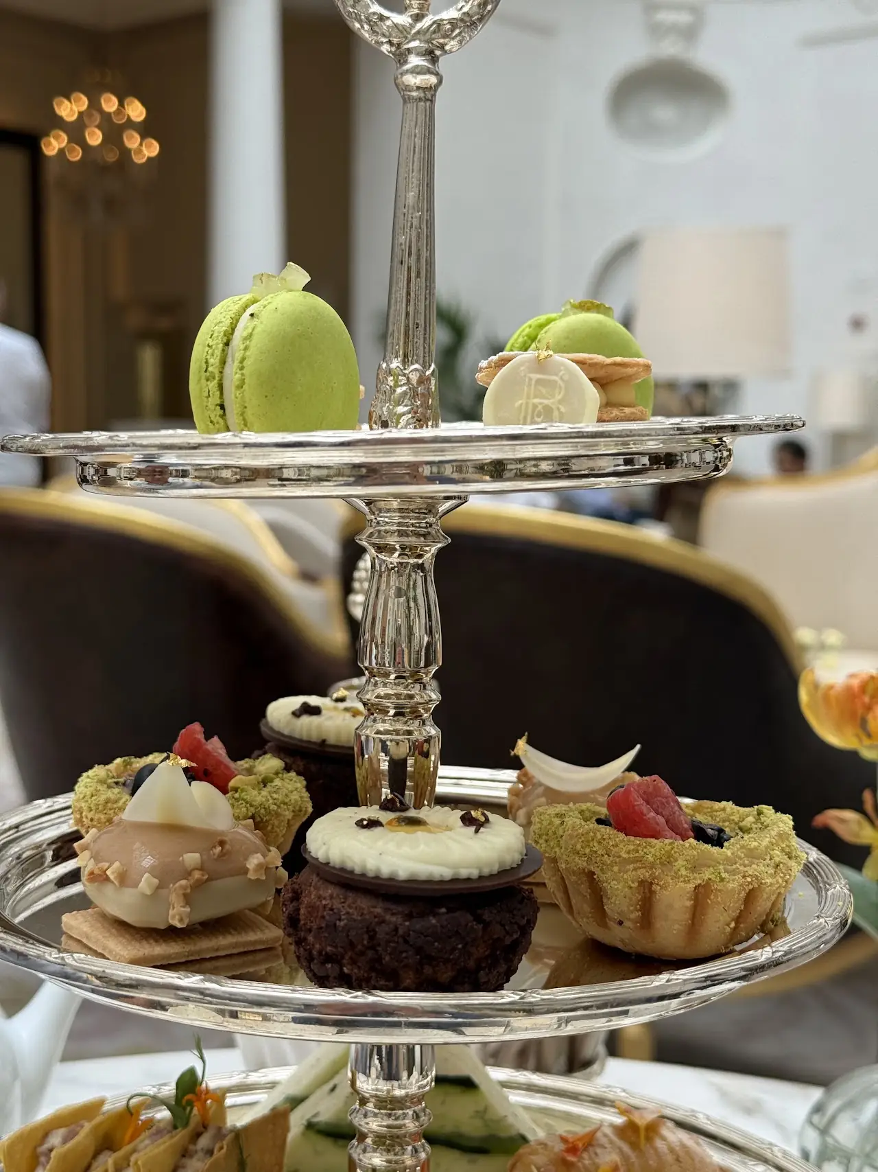 A three-tier stand of pastries and macarons for afternoon tea
