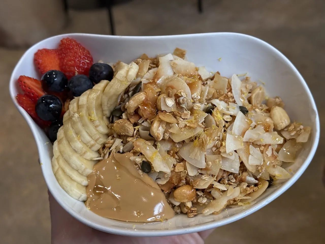 A bowl of nut butter, granola and toasted coconut