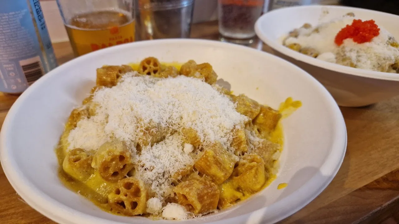 Bowl of rigatoni pasta topped with grated parmesan