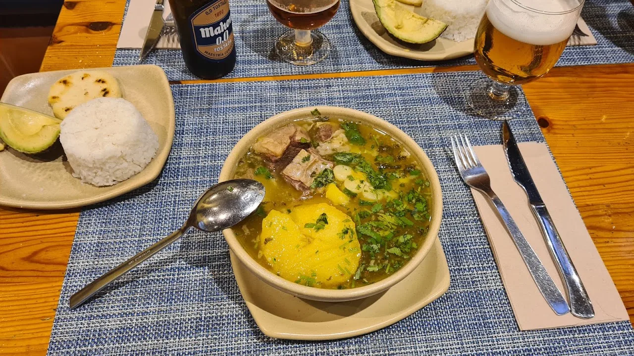 A bowl of soup with rice and a side of avocado