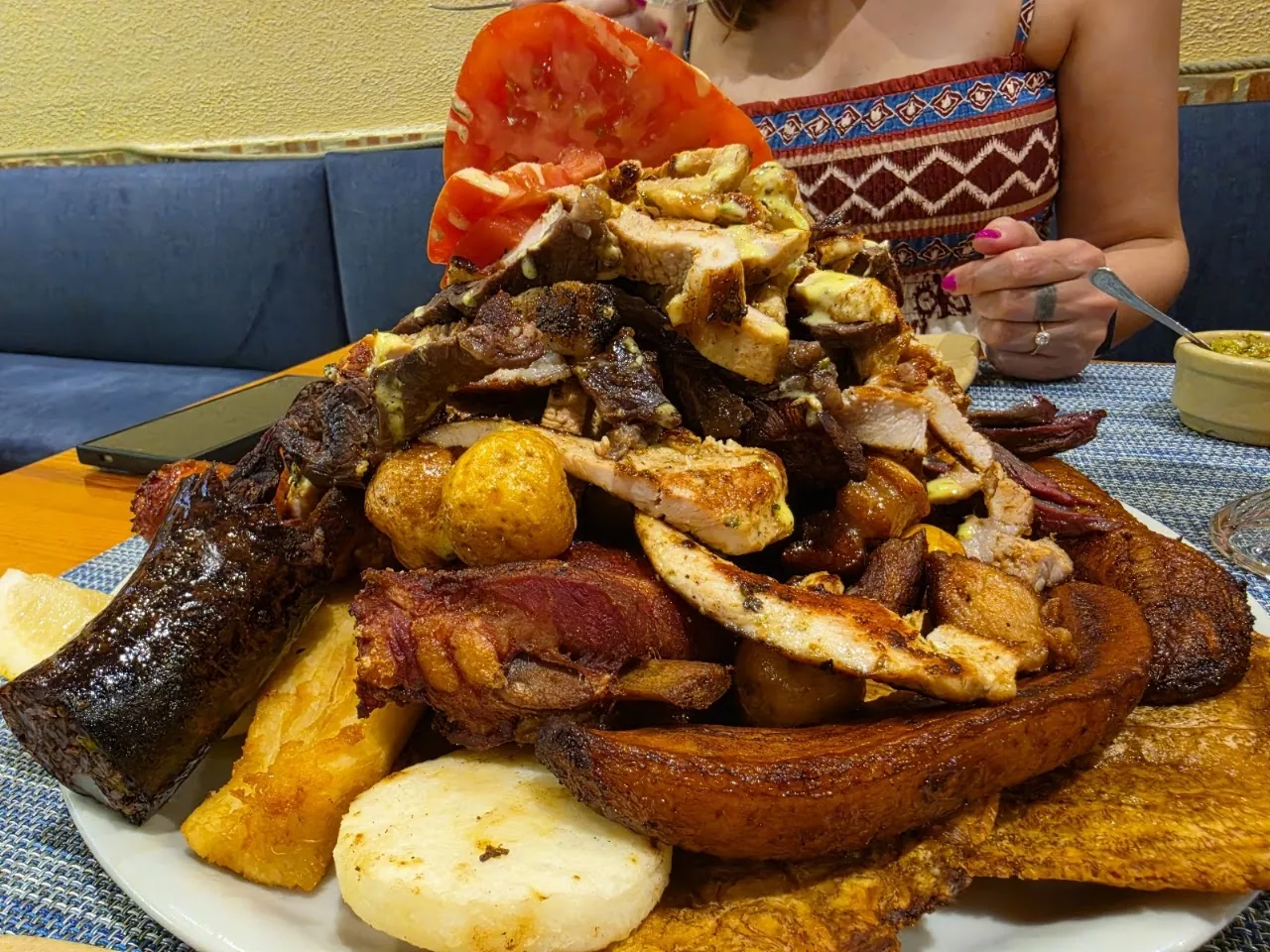 Grilled meat platter with fried plantains and a slice of cheese