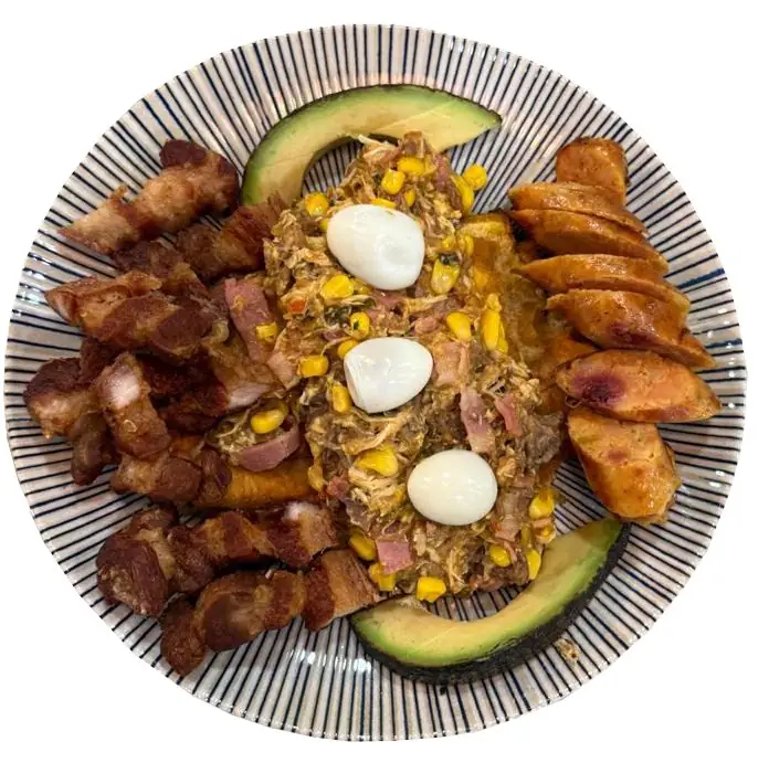 A loaded blue-striped bowl with fried pork belly, sliced chorizo, shredded meat with corn, quail eggs and avocado slices
