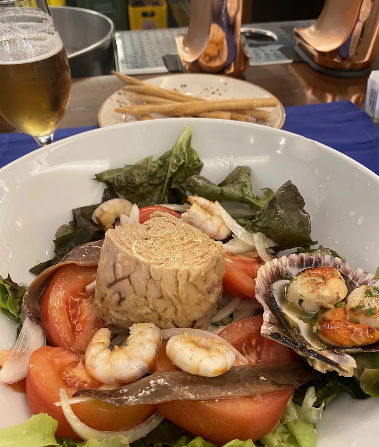 A seafood salad with shrimp, scallops, tomato, and greens
