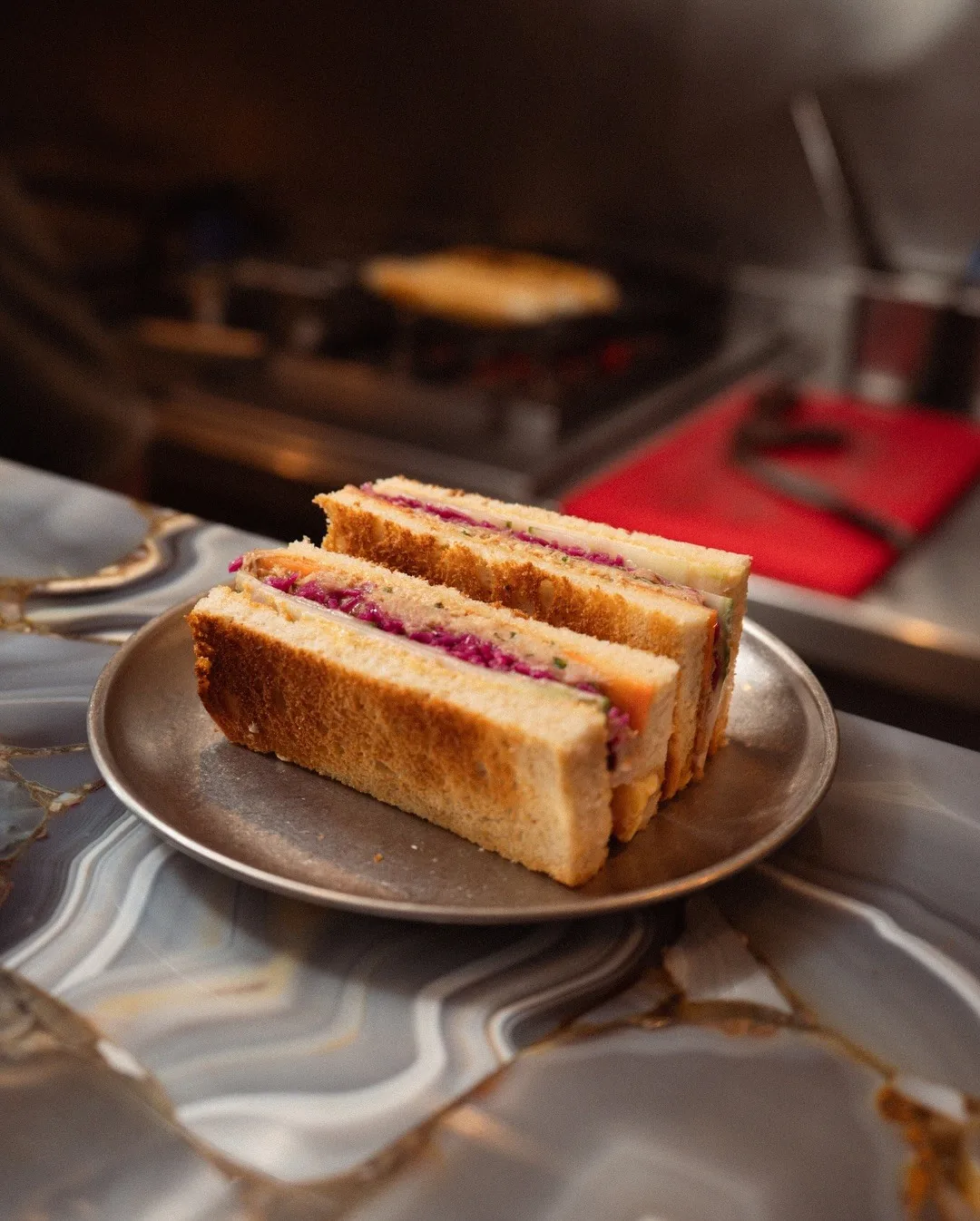 A club sandwich cut into triangles, stacked on a plate