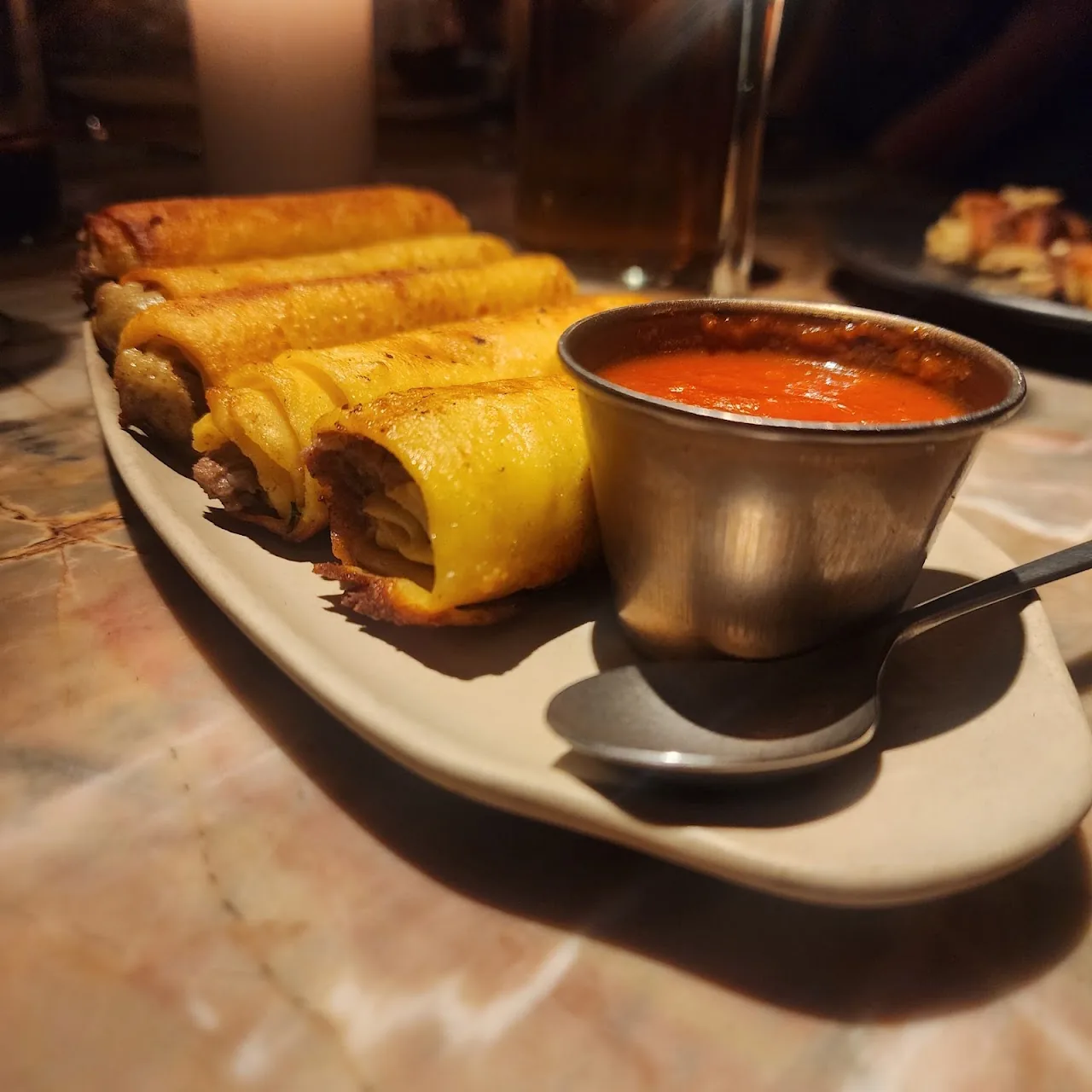 Rolled fried flautas served with a dipping sauce