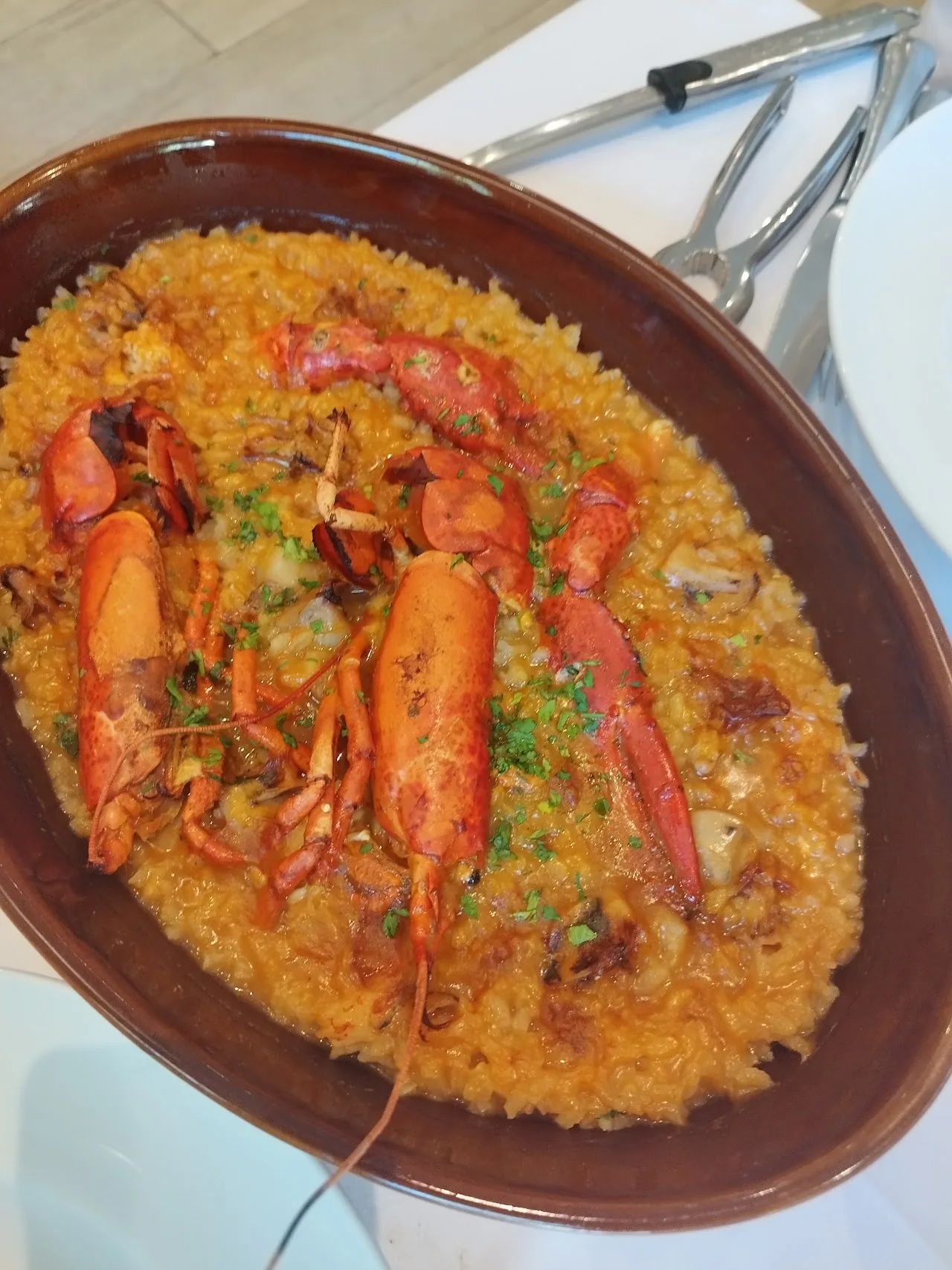 A pan of paella topped with whole lobster