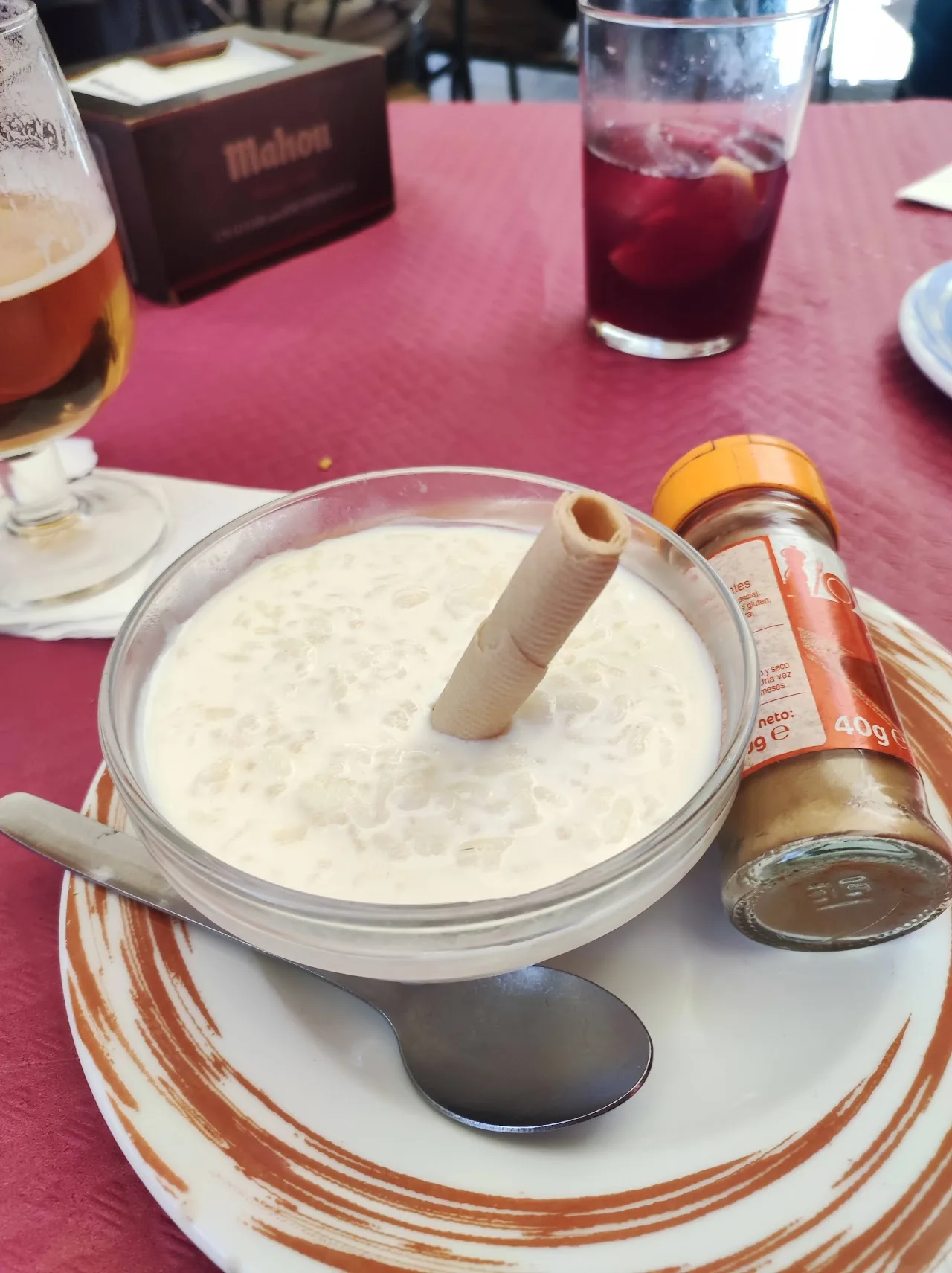 A bowl of pale, creamy soup garnished with a bread stick