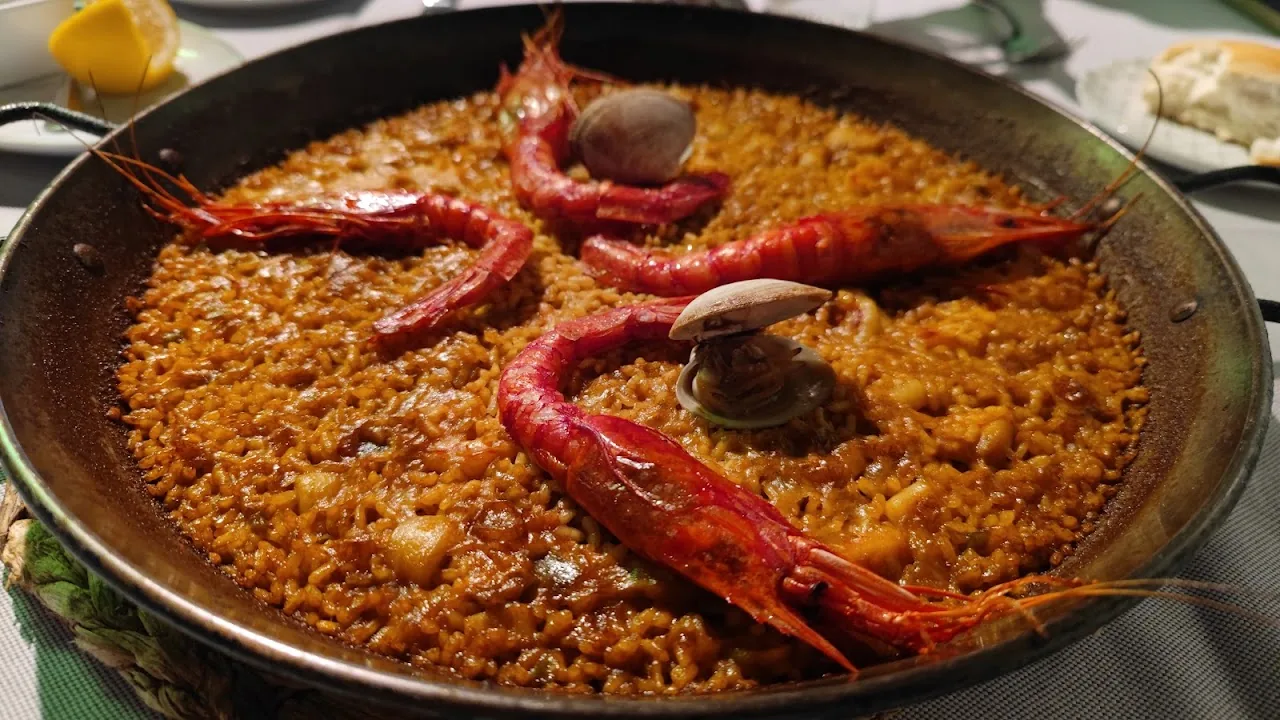 A pan of seafood paella with prawns and clams