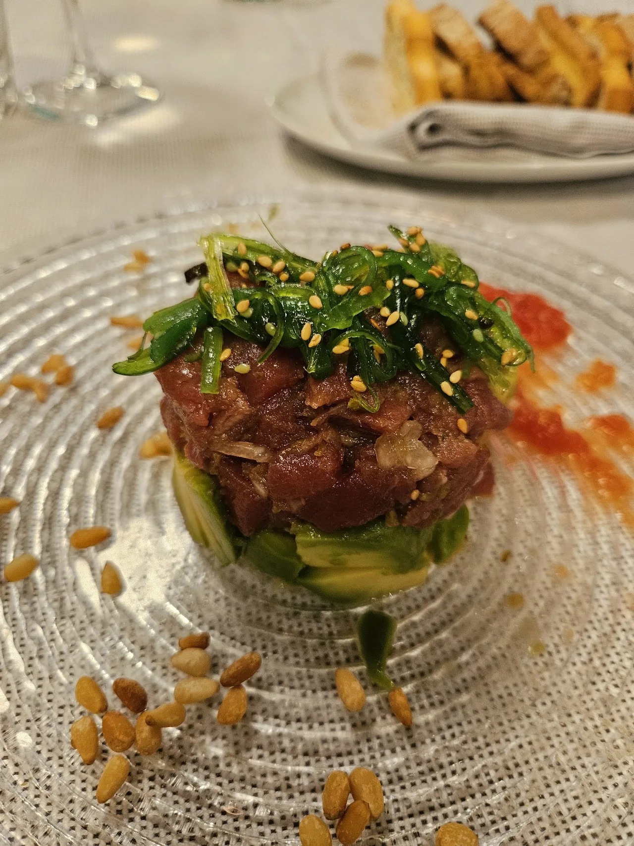 A stacked tuna tartare topped with sesame seeds