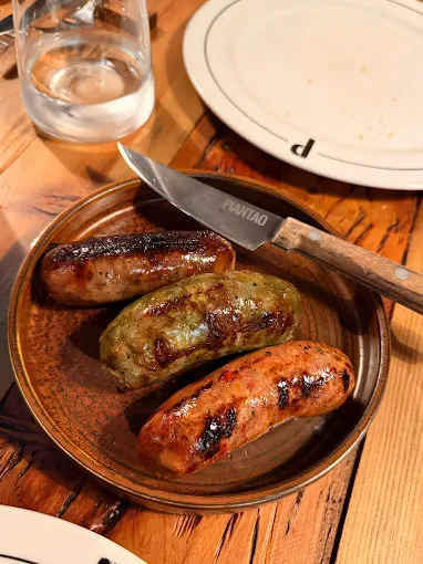 Grilled sausages on a wooden plate