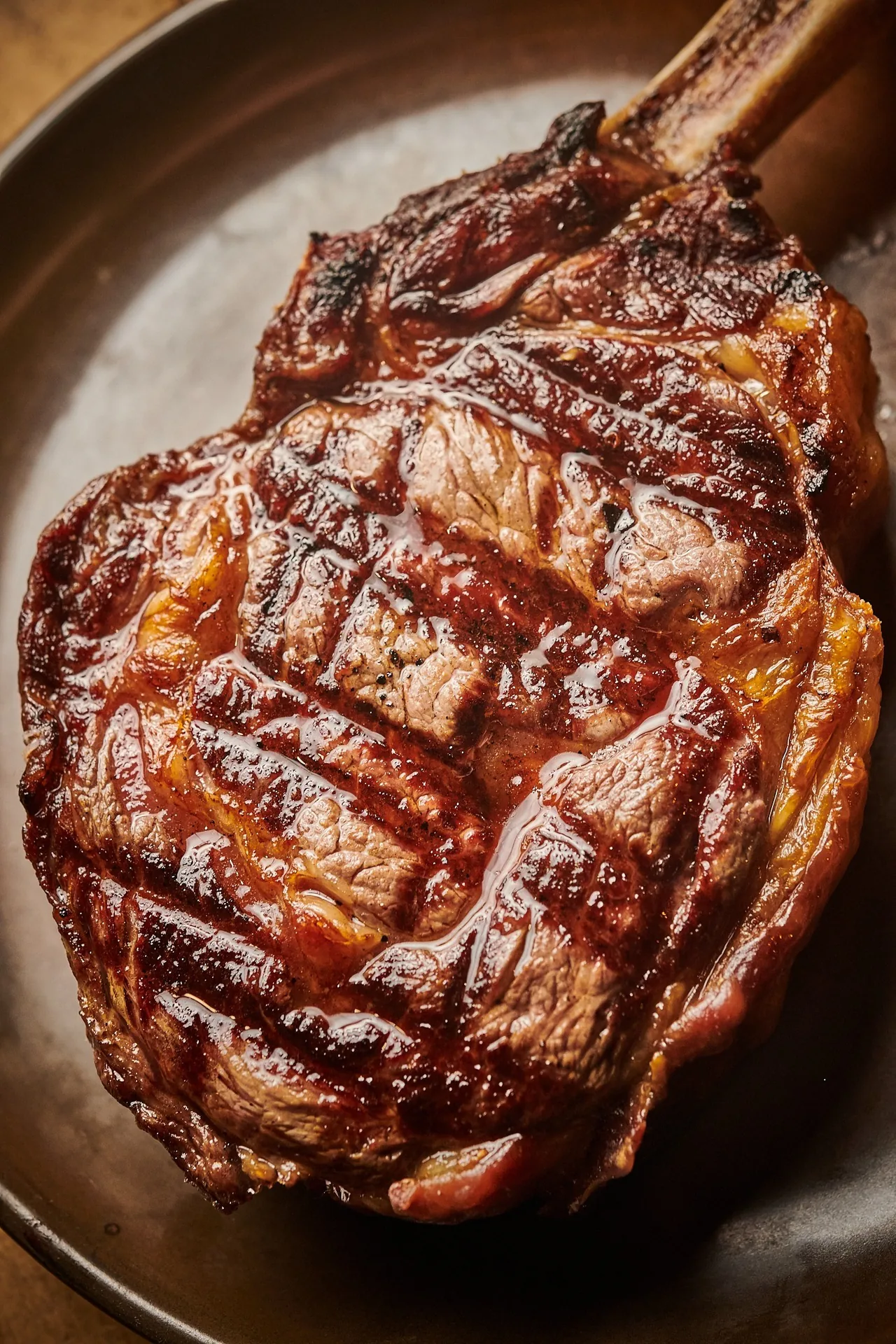 Close view of a thick grilled steak with crosshatch grill marks on a plate