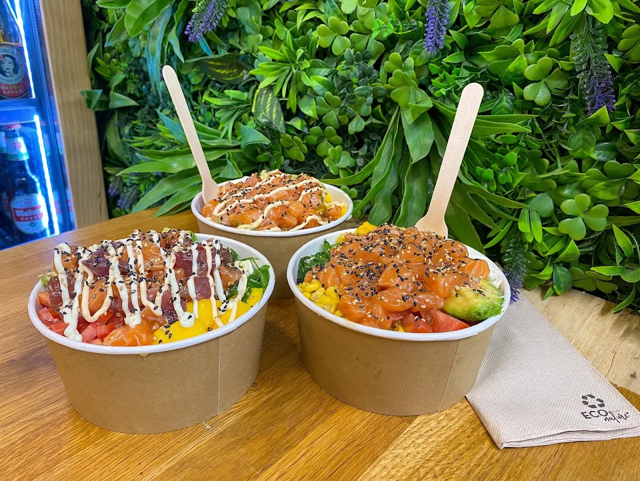 Two poke bowls with rice, salmon, and toppings, side by side
