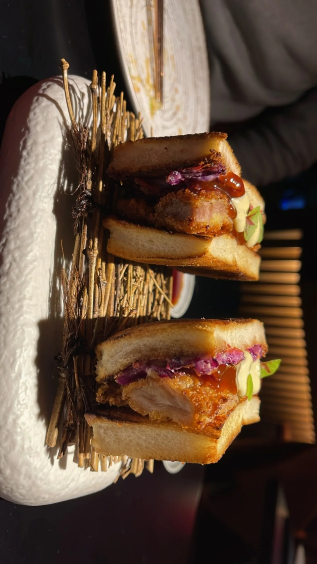 Small skewered sandwiches with pork belly, arranged on a stand