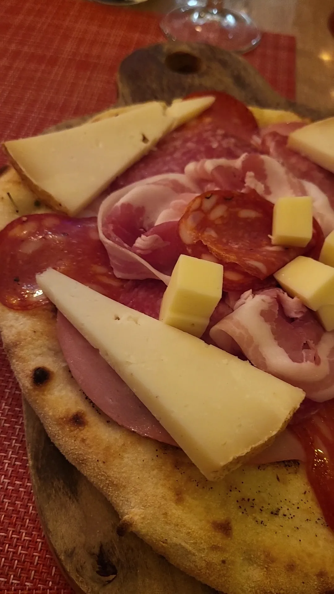 A board of sliced prosciutto and cheese with flatbread