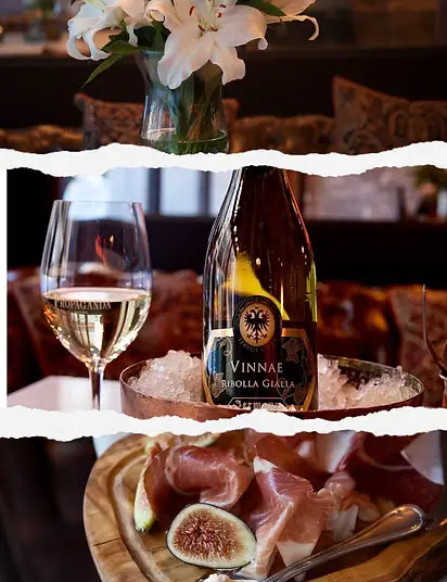 Torn-edge collage of a glass of white wine and a bottle of Vinnae Ribolla Gialla in an ice bucket above a board of figs and cured ham