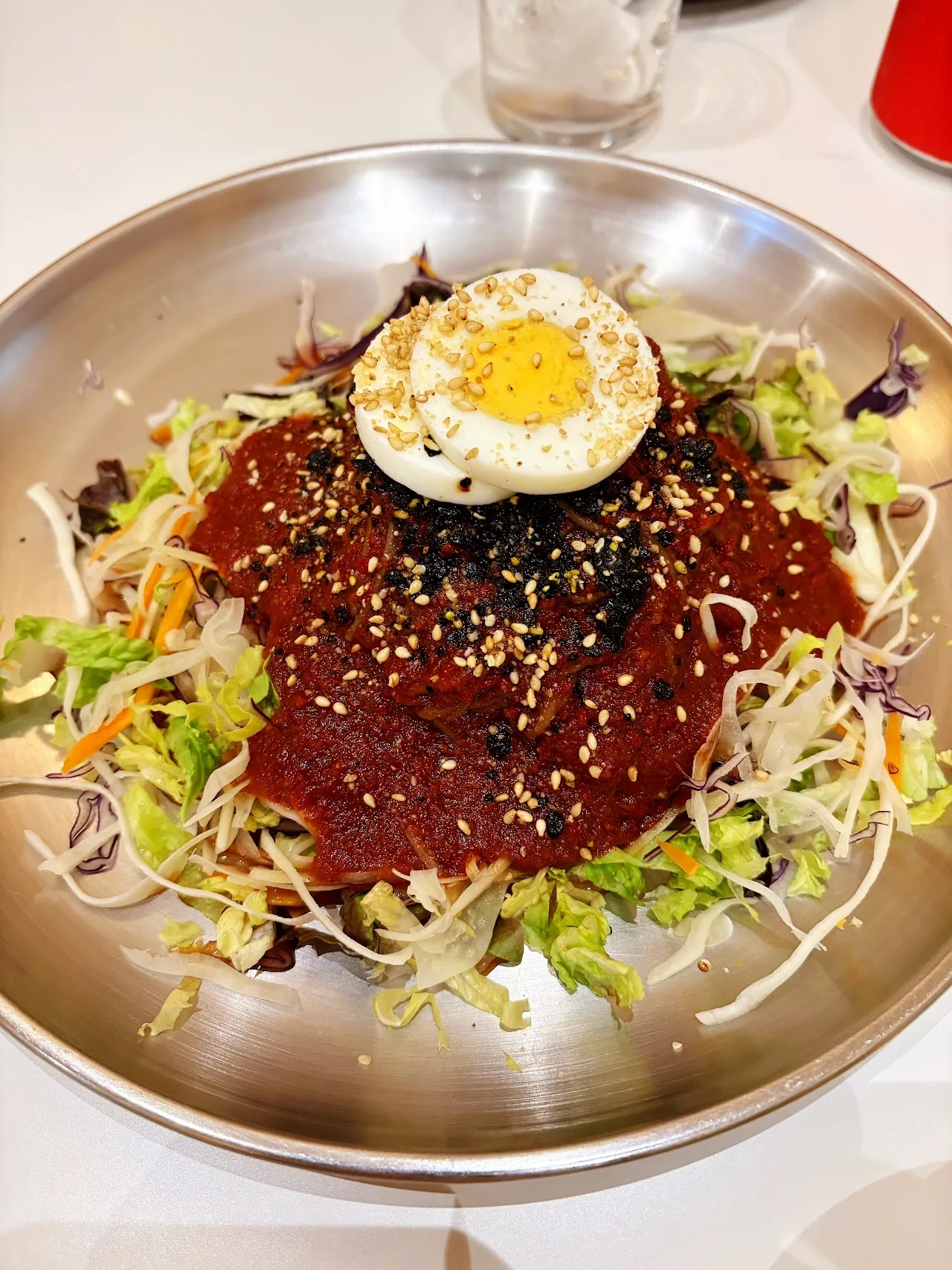 Korean beef tartare topped with a raw egg yolk over shredded vegetables