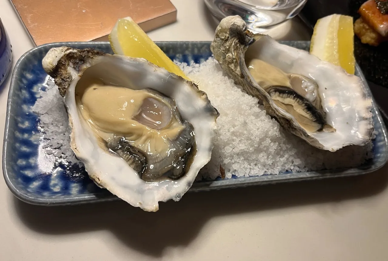 Fresh oysters on ice with a lemon wedge