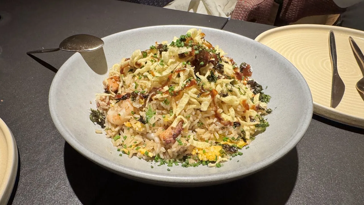 A bowl of stir-fried rice with herbs and diced meat
