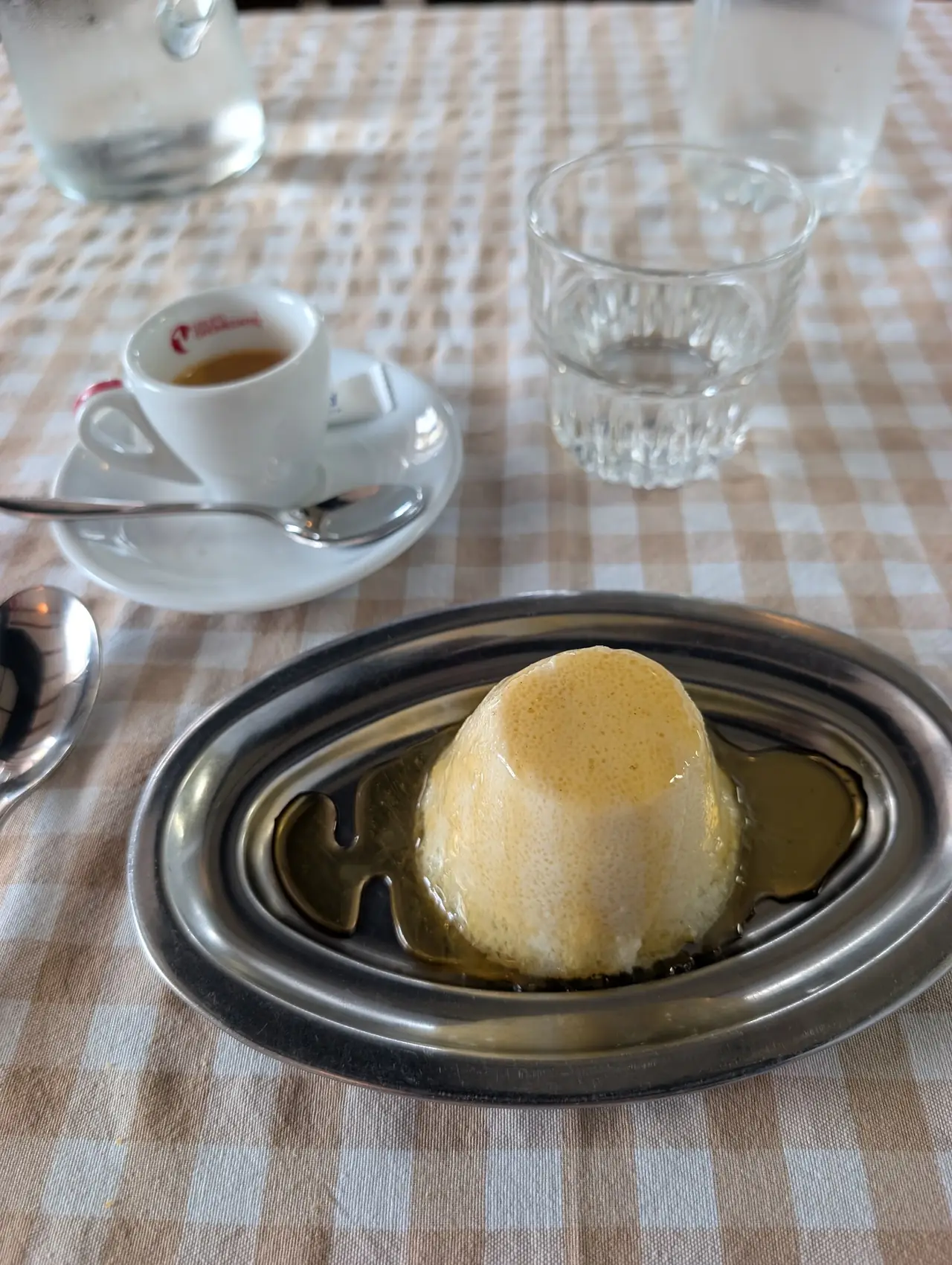 Flan-style dessert with caramel sauce next to an espresso