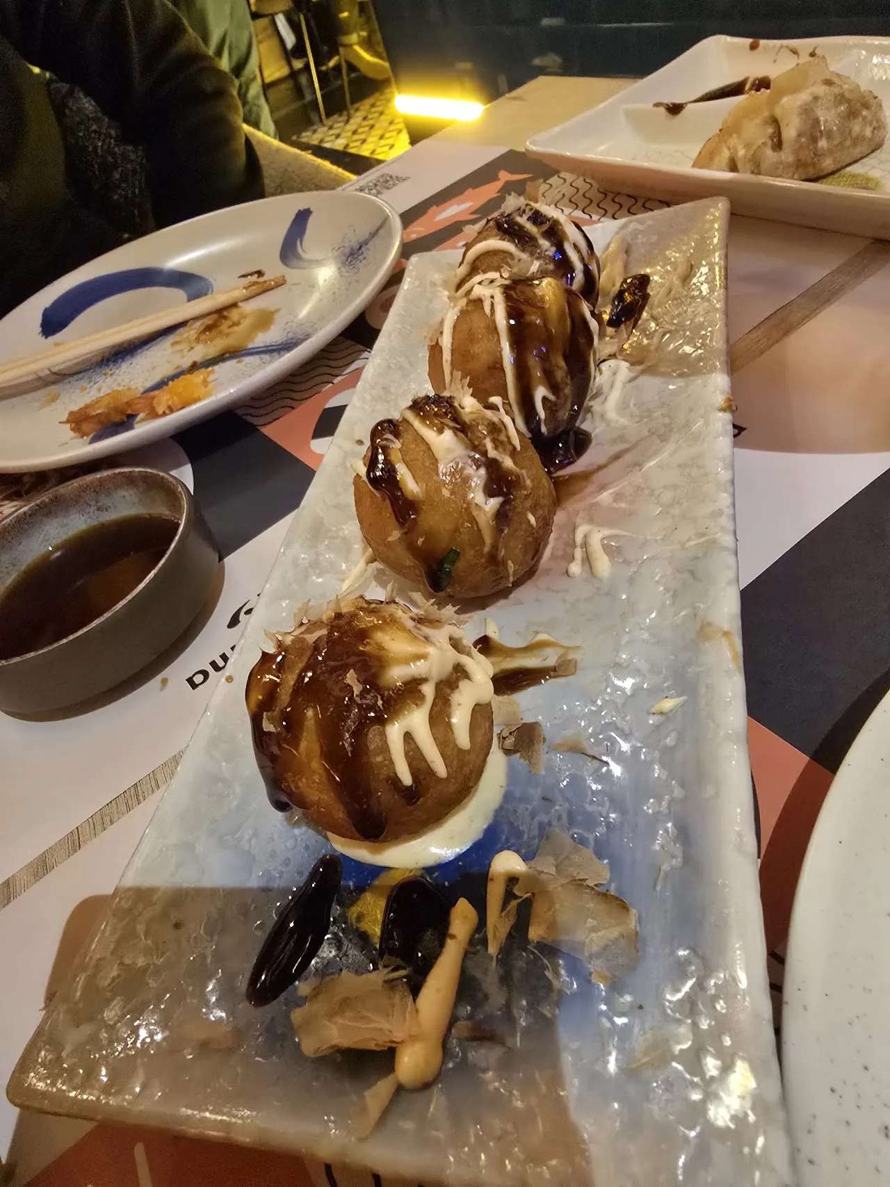A dessert plate with a pastry drizzled with chocolate sauce