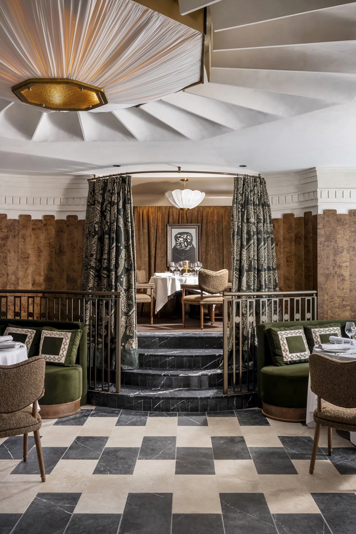 A dining room entrance with a checkerboard floor, steps, green curtains and a pleated ceiling