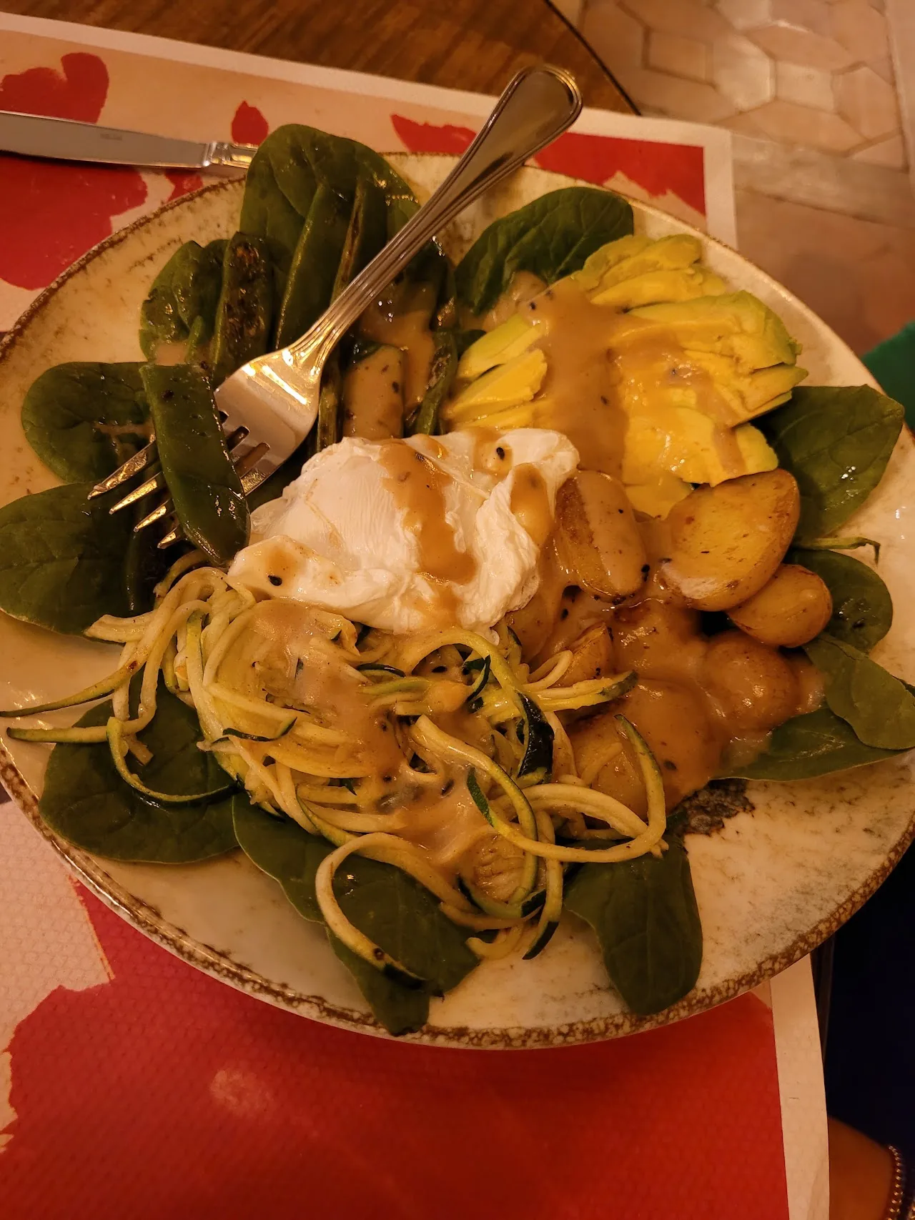 A plate of pasta with sautéed mushrooms and greens