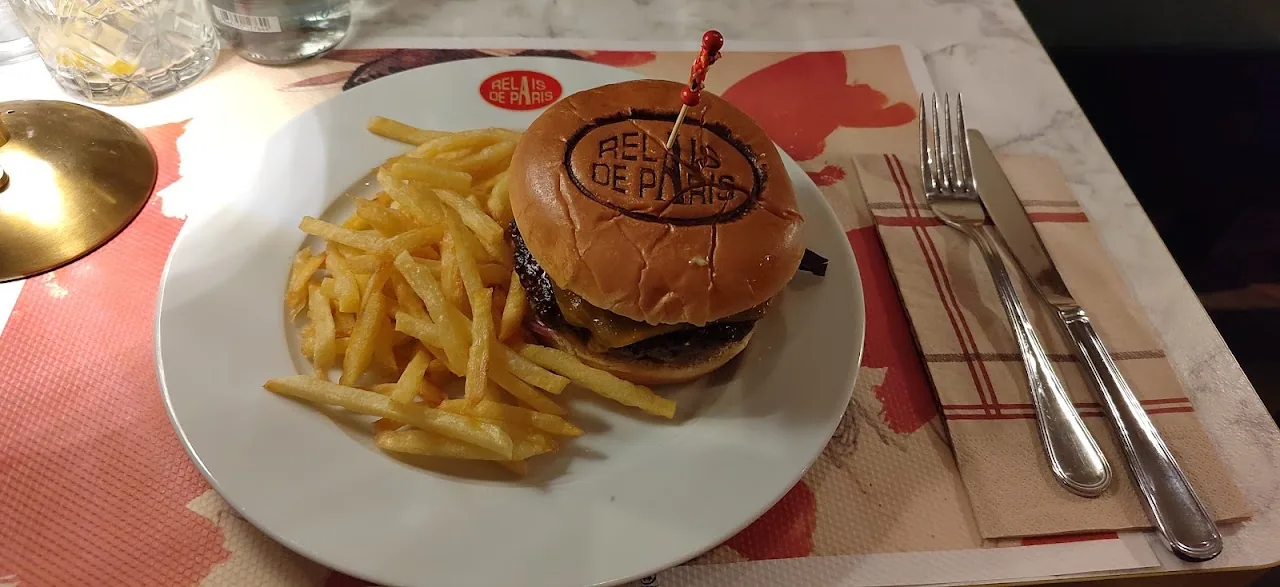 A burger topped with a fried egg, served with a side of french fries