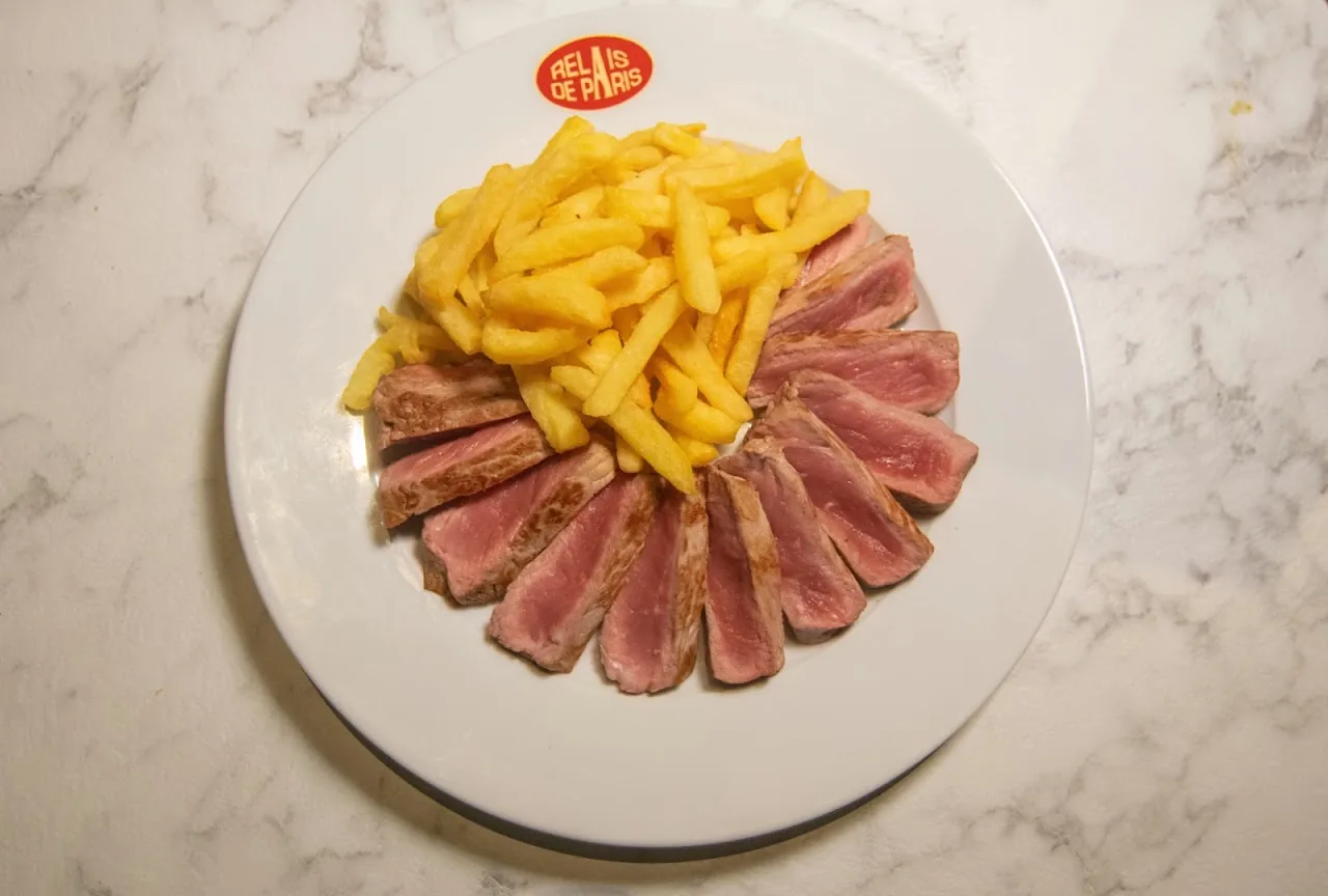 Thin slices of seared tuna tataki plated with a side of french fries