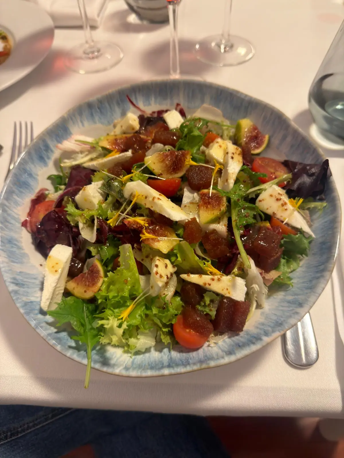 Green salad with beetroot, cubed cheese, and edible flowers