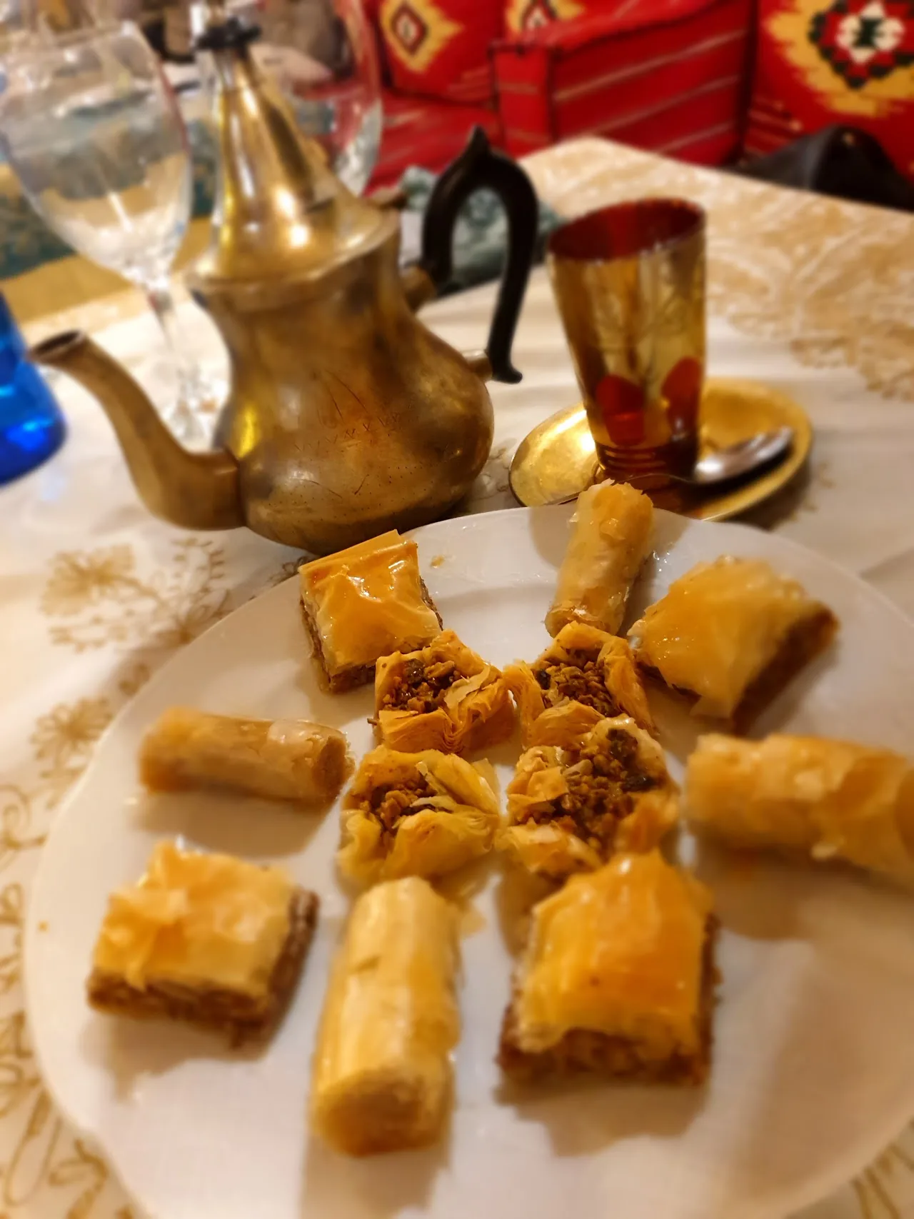A plate of baklava pastries served alongside a traditional teapot