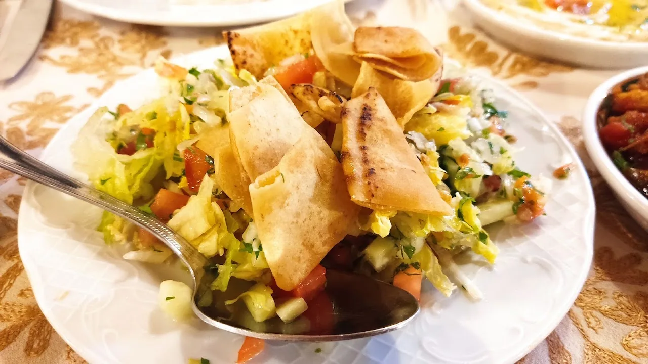 A salad topped with crispy pita chips