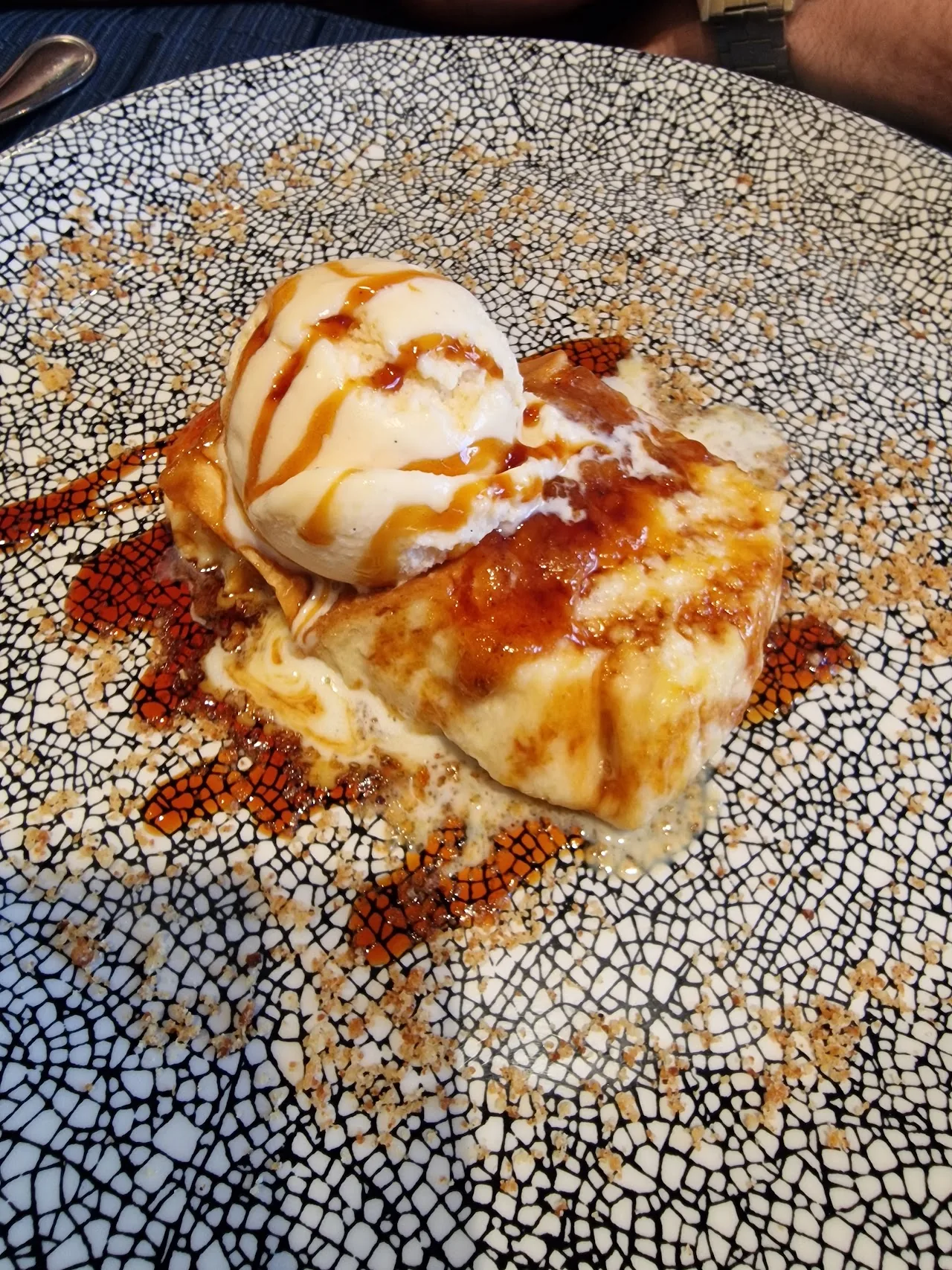 A scoop of ice cream over french toast with caramel sauce