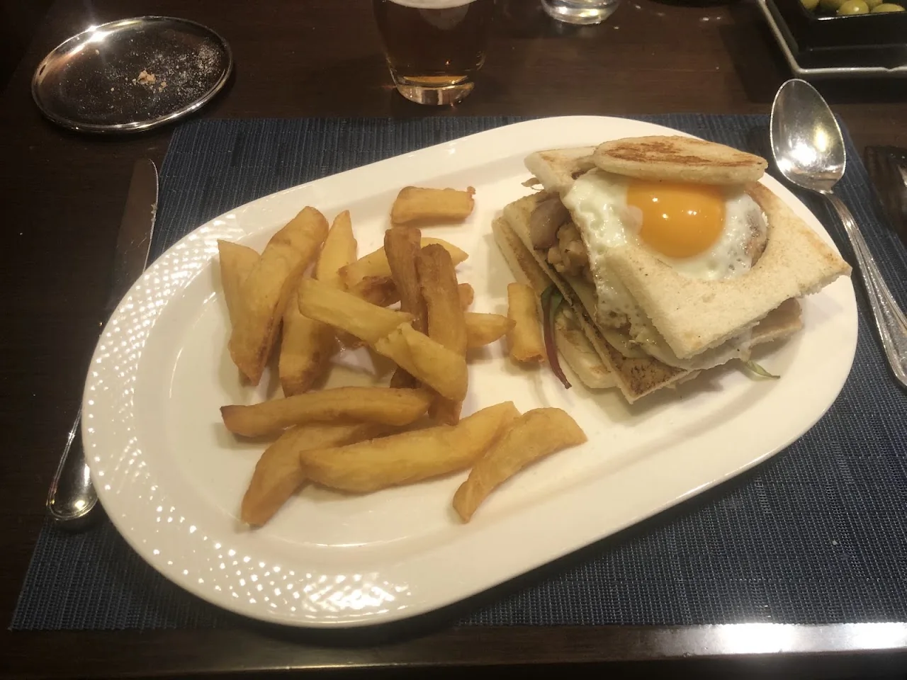A plate of fries beside a ham and egg sandwich