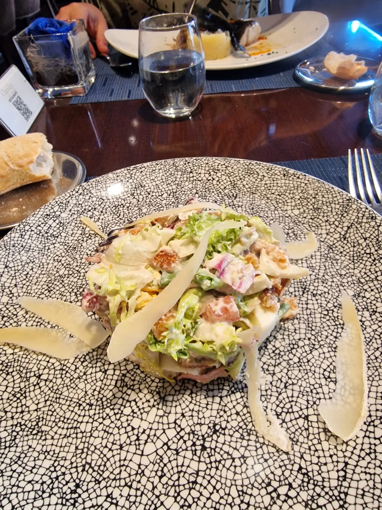 A chopped salad plate with shaved cheese on top
