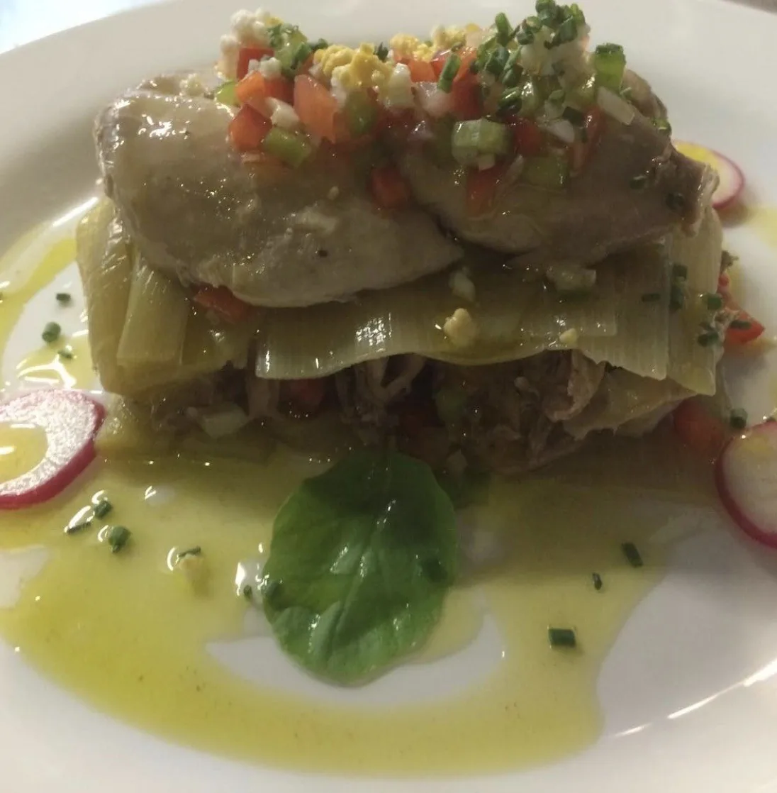 Layered pasta with a crab-style filling topped with chopped vegetables