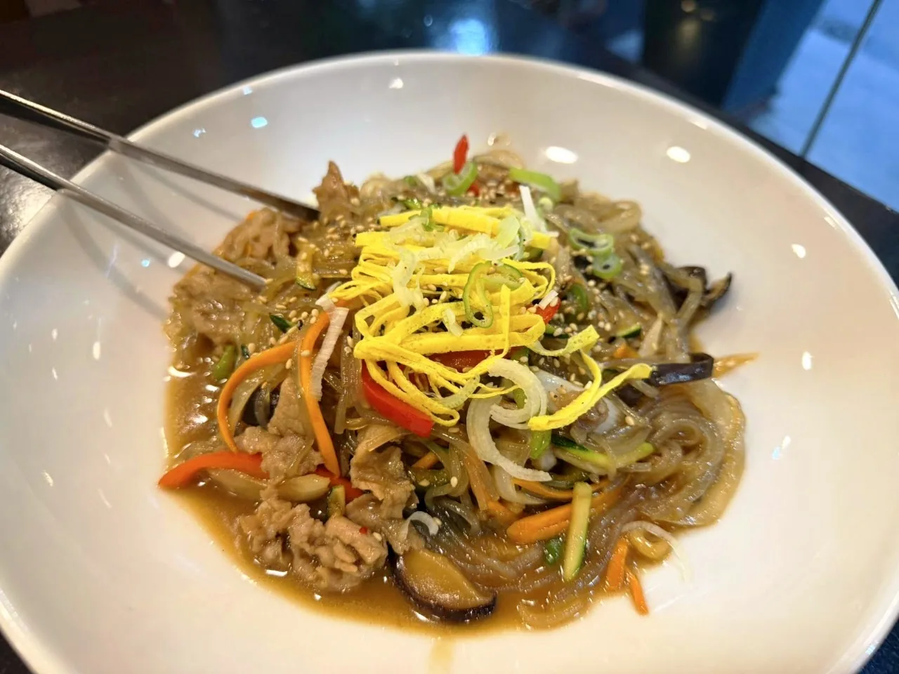 A bowl of pork stir-fry with mixed vegetables in sauce