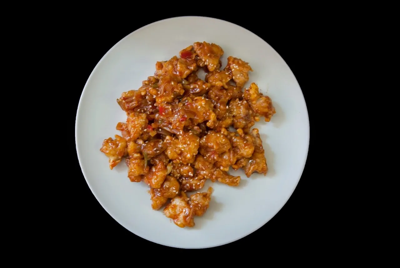 A plate of crispy sweet and spicy fried chicken pieces