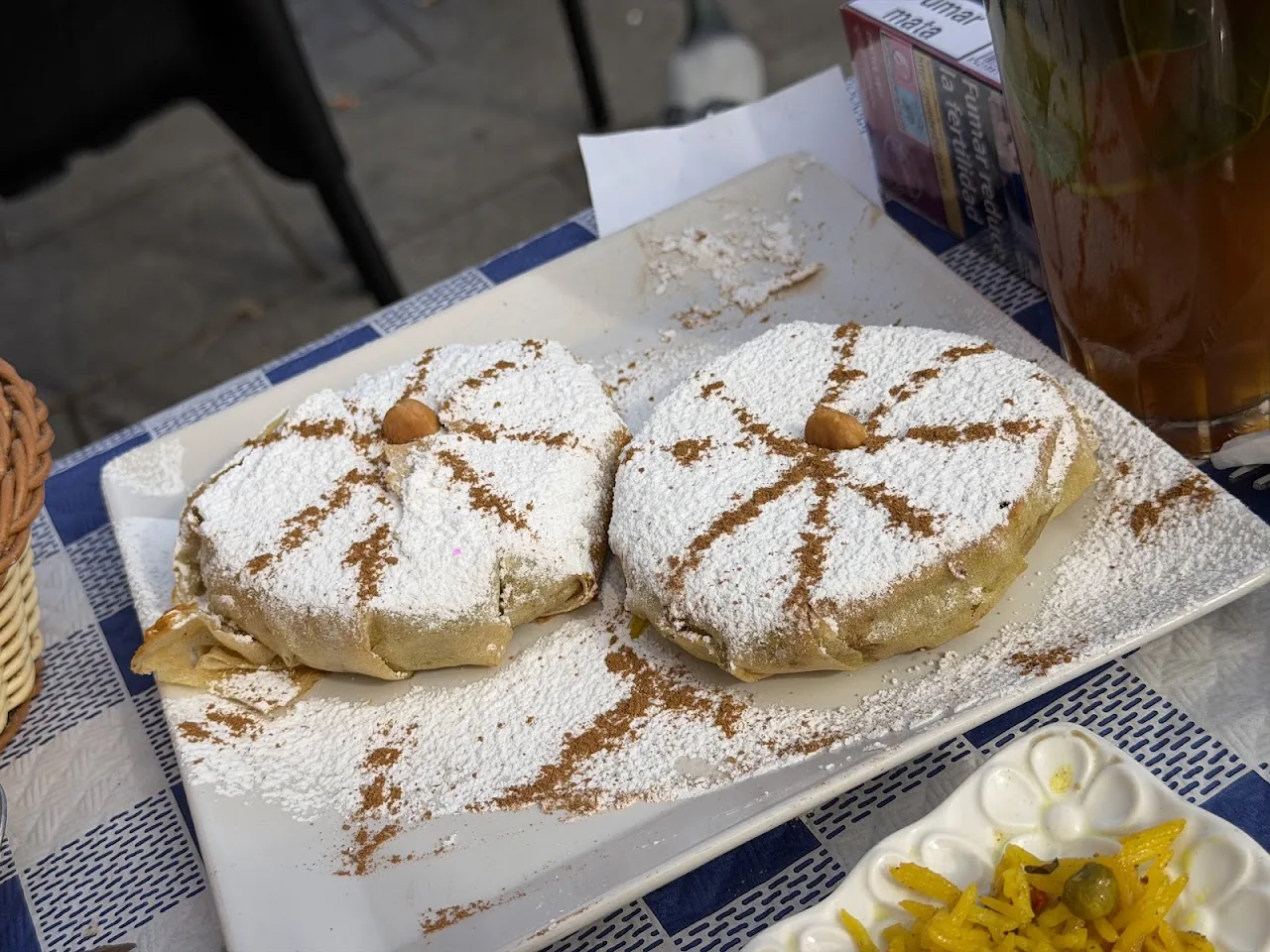 Two round pastries dusted with powdered sugar and cinnamon