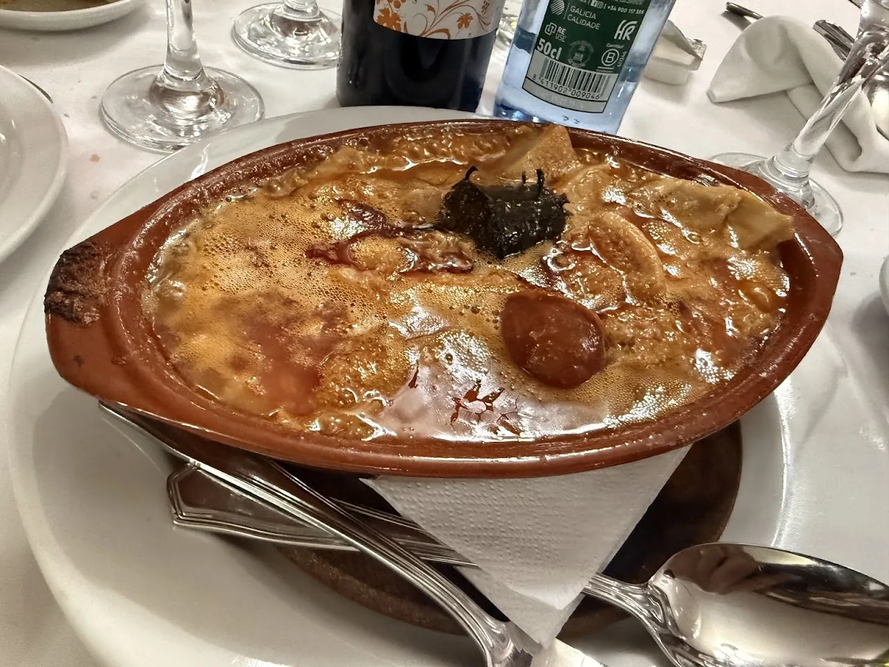 Cocido madrileno stew in a traditional clay pot with chickpeas and meat