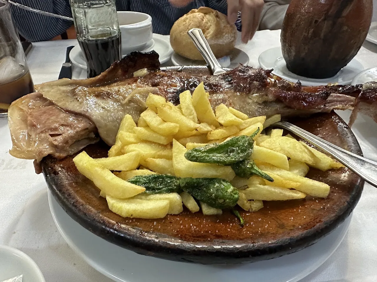 A grilled fish fillet with fries and sage on a plate