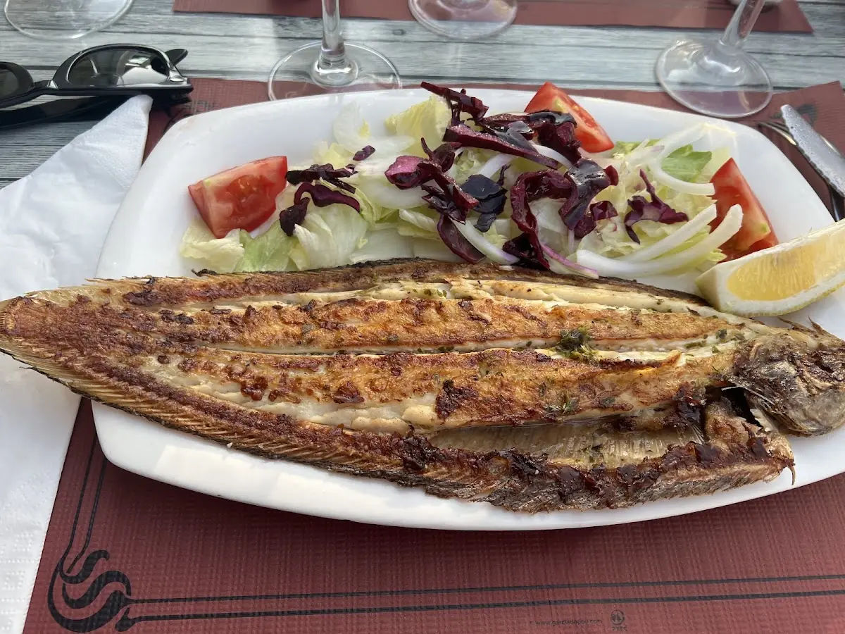 A whole grilled fish with salad at La Payesita
