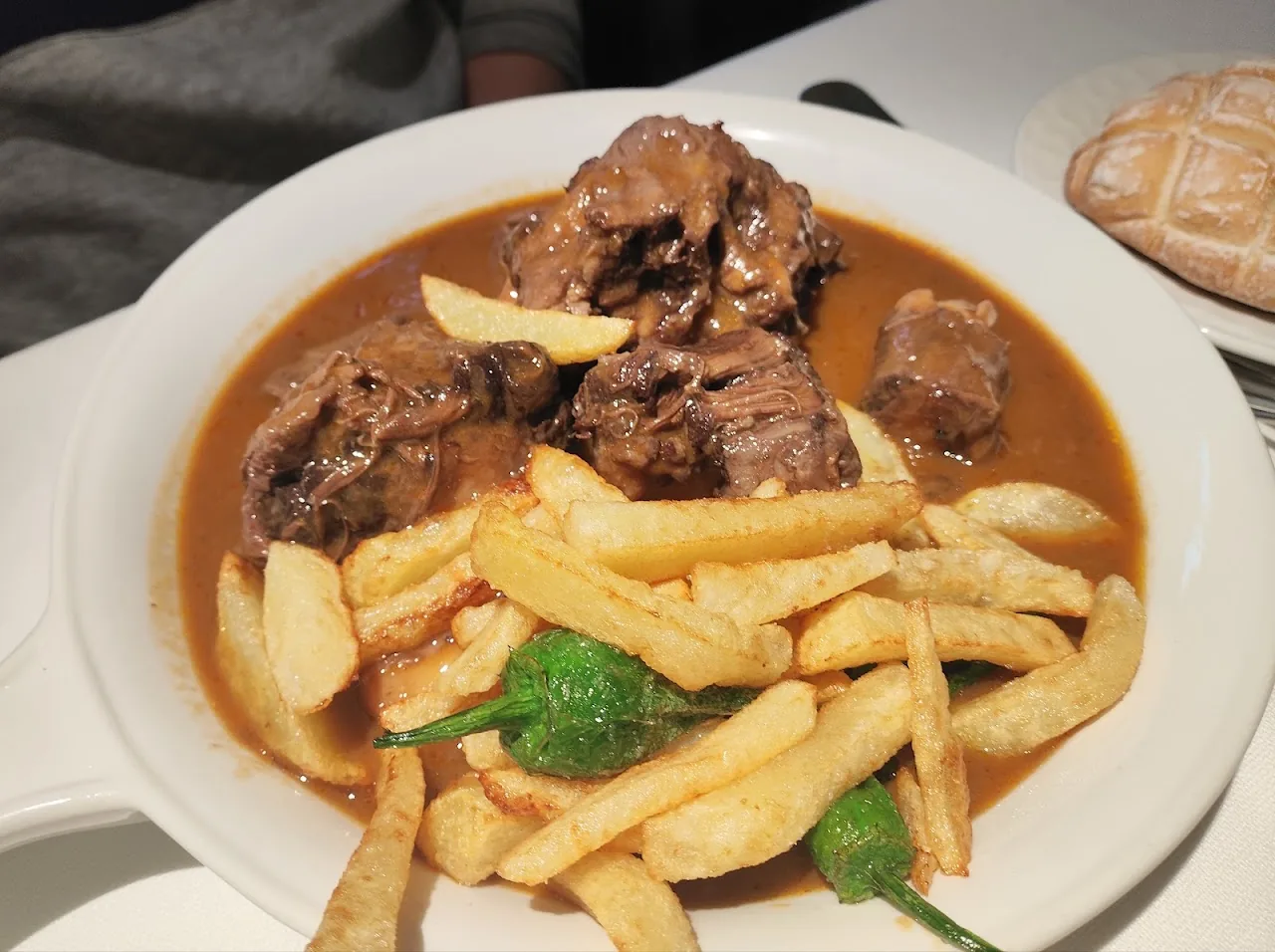 A plate of braised meat in sauce with french fries