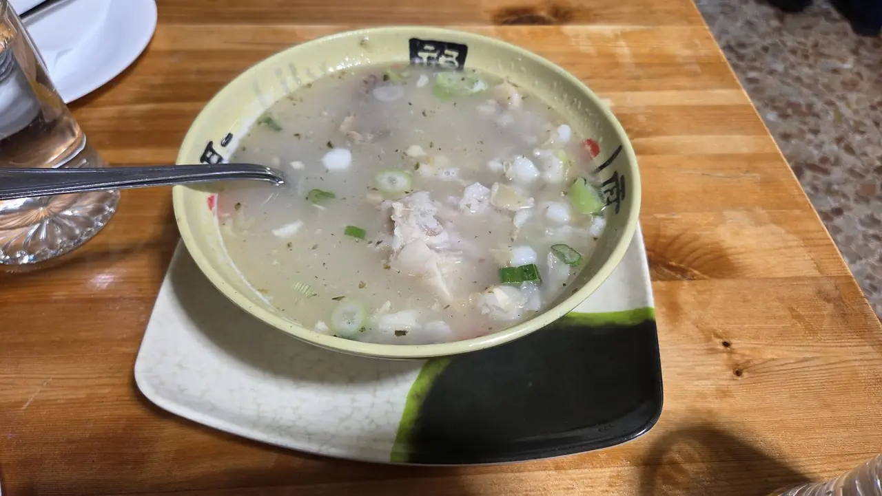 Bowl of fish soup with scallions and cilantro